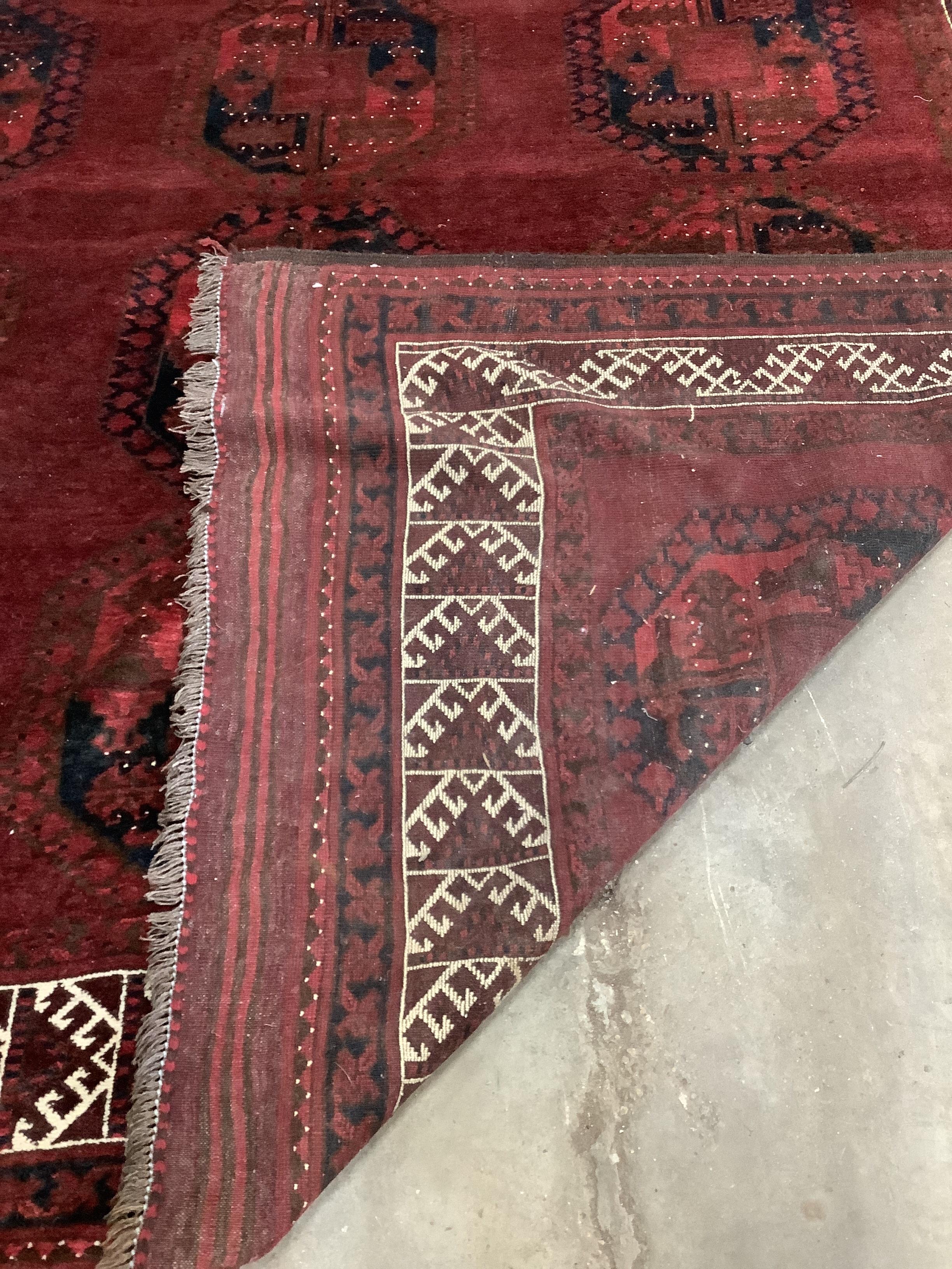 An Afghan red ground carpet, 380 x 243cm. Condition - fair